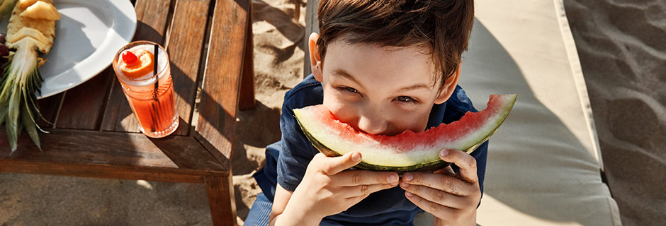 Glad gutt som spiser vannmelon